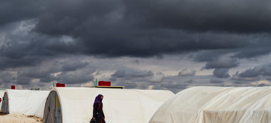 A Syrian woman walks at the Washukanni camp, photo by Delil Souleiman, AFP