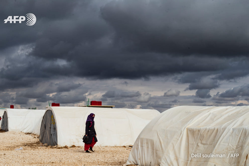 A Syrian woman walks at the Washukanni camp, photo by Delil Souleiman, AFP